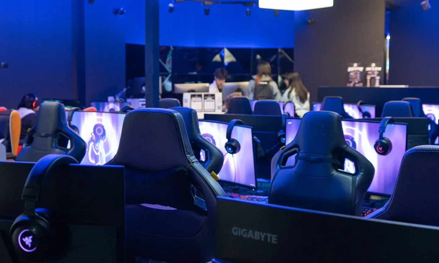 The blue-lit floor of Gala Box Hill, with rows of gaming chairs, monitors and headsets